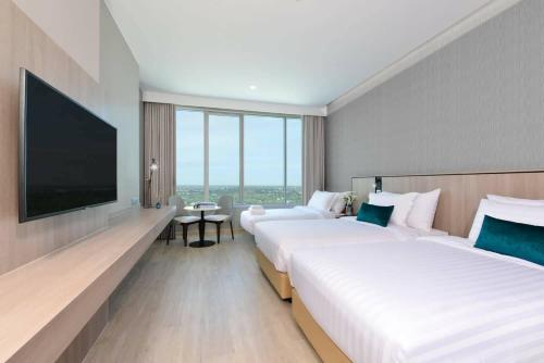 um quarto de hotel com duas camas e uma televisão de ecrã plano em Centre Point Hotel Terminal21 Korat em Nakhon Ratchasima