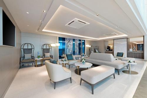 a living room with a couch and chairs and tables at Centre Point Hotel Terminal21 Korat in Nakhon Ratchasima