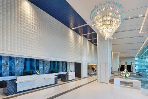 a lobby of a hotel with a chandelier at Centre Point Hotel Terminal21 Korat in Nakhon Ratchasima