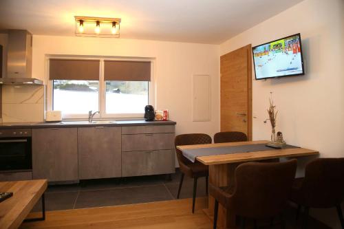 a kitchen with a sink and a table with chairs at M4 Appartements in Wagrain