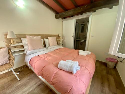 een slaapkamer met een groot bed en een roze deken bij Loft Florentia in Prato