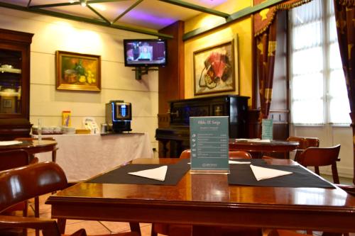 un restaurant avec une table et un panneau. dans l'établissement Hotel Alda El Suizo, à Ferrol