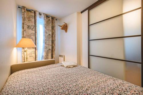 - une chambre avec un lit et une porte coulissante dans l'établissement CAMILLE - Appartement avec extérieur, à Reims