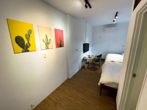 a room with a bed and paintings on the wall at Small Island Homestay in Tainan