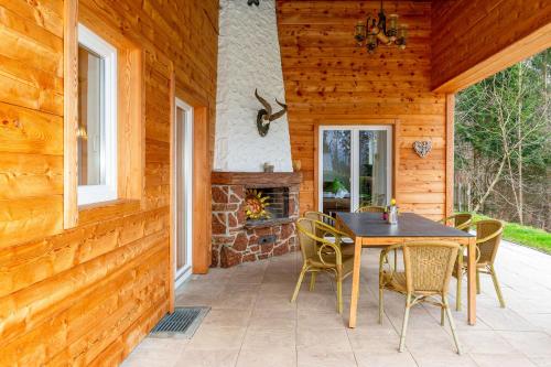 a patio with a table and chairs and a fireplace at Salzburg-Chalet in Grossgmain