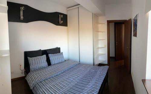 um quarto com uma cama com uma cabeceira preta em GIS North House em Bucareste