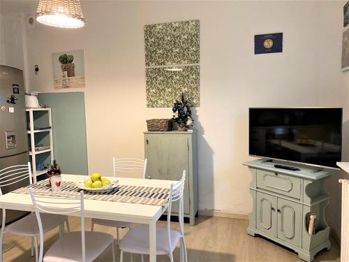 uma cozinha e sala de jantar com uma mesa e uma televisão em Casa Matì em Altedo