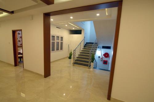 a hallway with a staircase in a house at Gateway Airport Hotel in Kannur