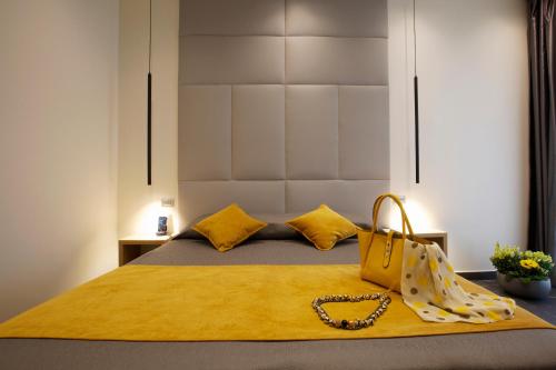 a bed with a yellow blanket and a yellow purse at Hotel Garden in Levanto
