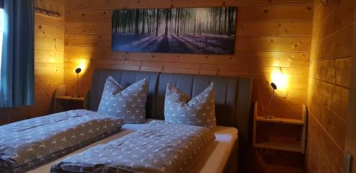 two beds in a room with wooden walls at Blockhäuser Stamsried in Stamsried