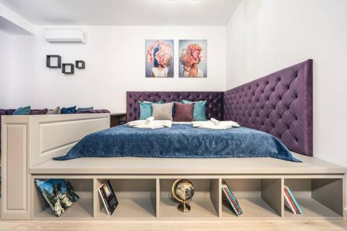 a bedroom with a purple bed and a purple headboard at Briana Luxury Panoramic View in Cluj-Napoca