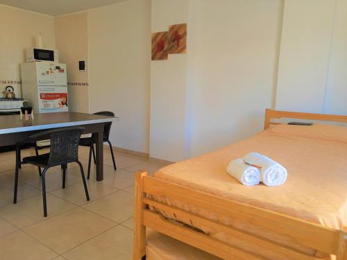 a bedroom with a bed and a desk and a table at Hotel Brisas in Villa Carlos Paz