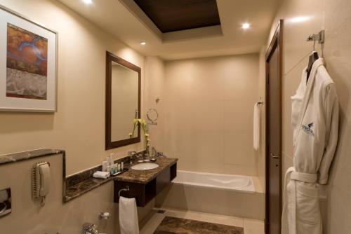 a bathroom with a sink, toilet and bathtub at Concorde Hotel Doha in Doha