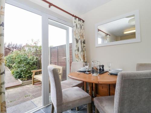 a dining room with a table and chairs and a window at Jay Cottage in Weymouth