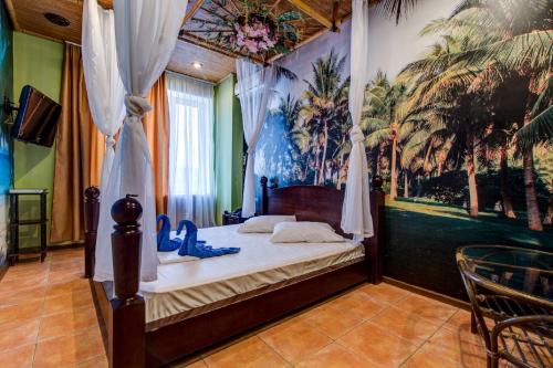 a bedroom with a canopy bed with a mural of palm trees at Bansay in Dnipro