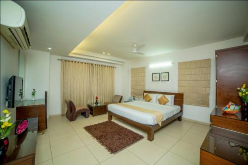 a bedroom with a bed and a desk and a television at Hill View Hitech City in Hyderabad