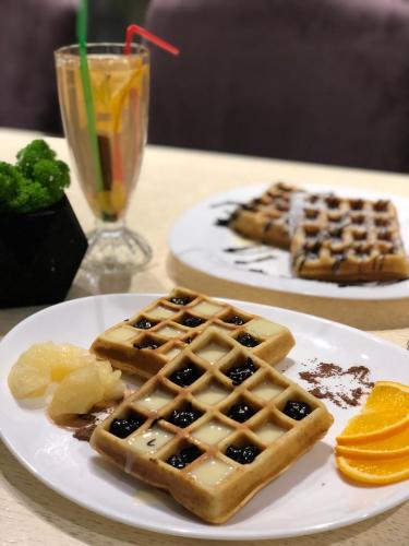 two plates of waffles and oranges on a table at Motel Kurortnyy & SPA in Shklo