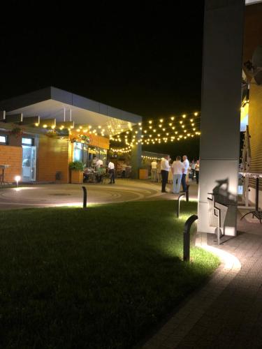 a group of people standing outside of a building at night at Motel Kurortnyy & SPA in Shklo