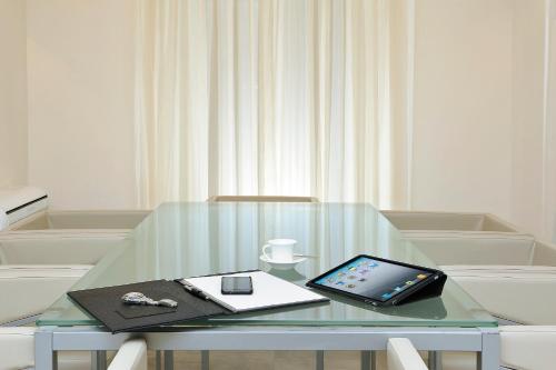 a glass table with a tablet on top of it at Demetra Hotel in Rome