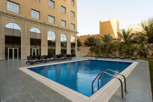 a large swimming pool in a large building at Concorde Hotel Doha in Doha