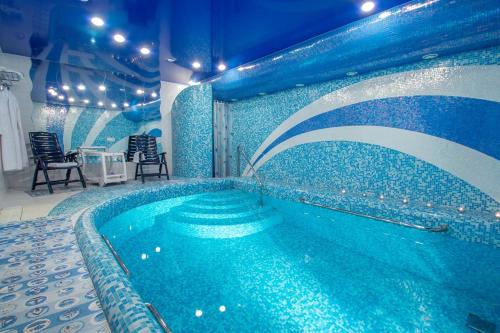 a swimming pool in a room with a blue wall at 13 Chairs Boutique Hotel in Petrozavodsk