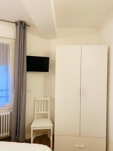 a bedroom with a bed and a chair and a cabinet at B&B The Secret Place in Cavedago