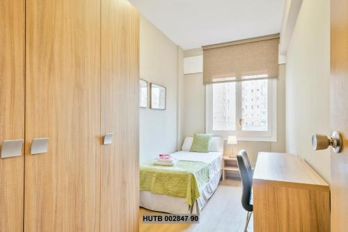 a small bedroom with a bed and a window at Alcam Provenza in Barcelona