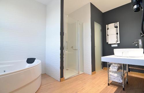 a bathroom with a tub and a sink and a shower at UVE Alcobendas in Alcobendas