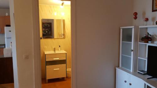 a small bathroom with a sink and a mirror at Apartamento cerca del mar in Matalascañas