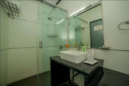 uma casa de banho com um lavatório e uma cabina de duche em vidro. em HILL VIEW (VOILA TRANQUIL'N) BEGUMPET em Hyderabad