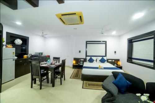 um quarto com uma cama, uma mesa e cadeiras em HILL VIEW (VOILA TRANQUIL'N) BEGUMPET em Hyderabad