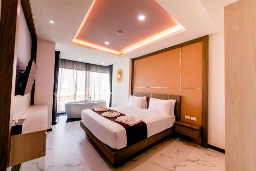 a hotel room with a bed and a bath tub at The Proud Hotel Pattaya - SHA Certified in Pattaya North