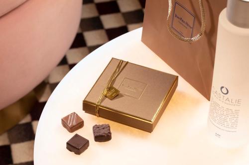 a box of chocolate on a table next to a bag at Hotel Phileas Lazare & Spa - Opera in Paris