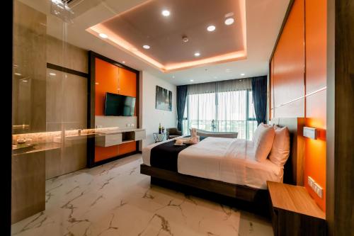 a hotel room with a bed and a television at The Proud Hotel Pattaya - SHA Certified in Pattaya North