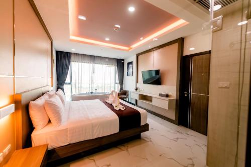 a bedroom with a bed and a television in a room at The Proud Hotel Pattaya - SHA Certified in Pattaya North