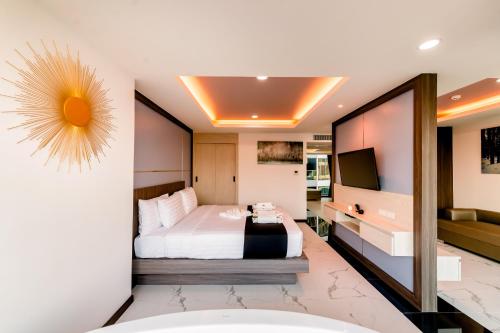 a hotel room with a bed and a television at The Proud Hotel Pattaya - SHA Certified in Pattaya North