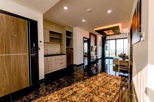 a kitchen with a marble floor and a door at The Proud Hotel Pattaya - SHA Certified in Pattaya North