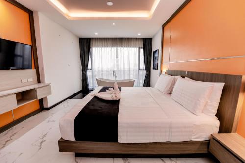 a bedroom with a large bed in a room at The Proud Hotel Pattaya - SHA Certified in Pattaya North