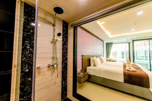 a bedroom with a bed and a shower and a tub at The Proud Hotel Pattaya - SHA Certified in Pattaya North