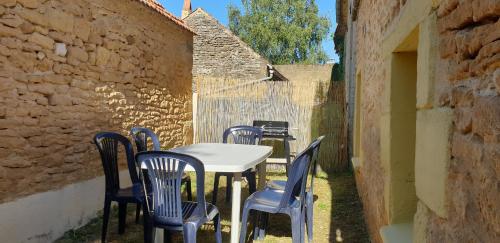 einen Tisch und Stühle in einer Gasse in der Unterkunft Petite maison en pierre au coeur du Périgord noir proche de Sarlat et Rocamadour in Salignac Eyvigues
