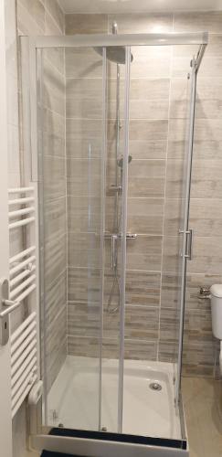 une douche avec une porte vitrée dans une salle de bain dans l'établissement Petite maison en pierre au coeur du Périgord noir proche de Sarlat et Rocamadour, à Salignac Eyvigues