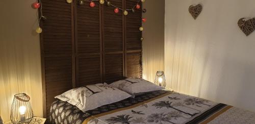 une chambre avec un lit avec une tête de lit en bois dans l'établissement Petite maison en pierre au coeur du Périgord noir proche de Sarlat et Rocamadour, à Salignac Eyvigues