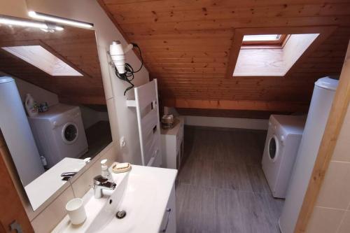 a bathroom with a sink and a toilet and a mirror at Ravissant appart proche suisse et pistes de ski familiales in Les Fourgs