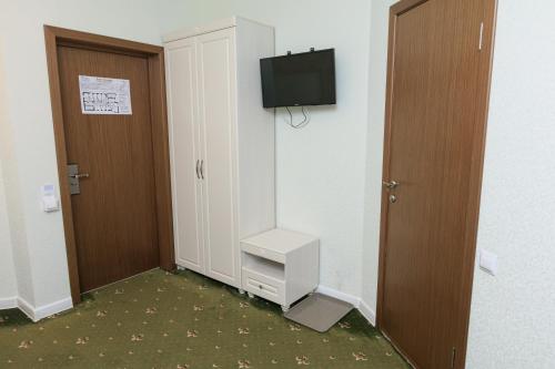 a room with a door and a television on a wall at VEGA Hotel in Arkhangelsk