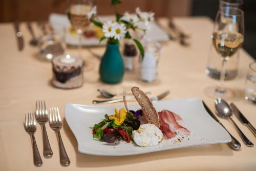 a table with a plate of food on a table at Hotel Zum Mohren in Resia