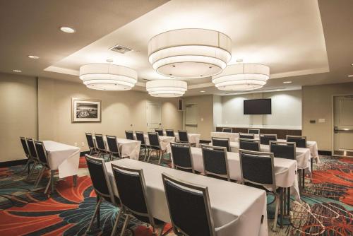 a conference room with white tables and chairs and a screen at La Quinta by Wyndham Kingman in Kingman