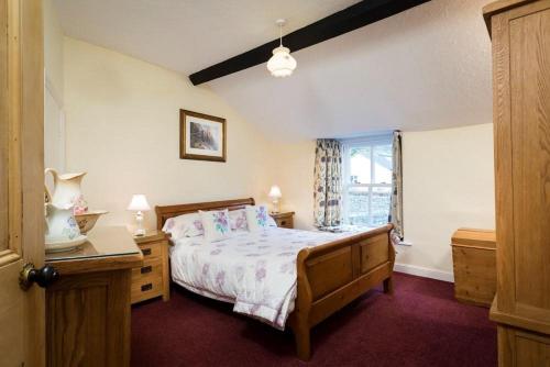 Sunbeam Cottage في كونيستون: غرفة نوم بسرير كبير ونافذة