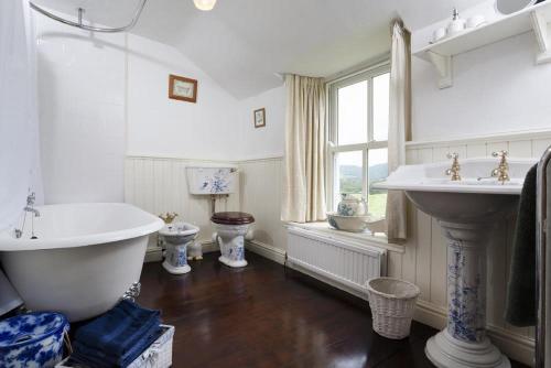 Sunbeam Cottage في كونيستون: حمام مع حوض ومغسلة ودورتين مياه
