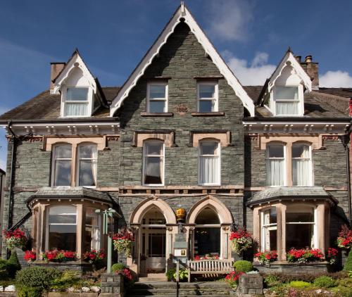 ein altes Haus mit Blumen davor in der Unterkunft The Edwardene in Keswick