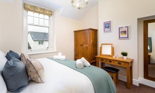 sypialnia z łóżkiem, stołem i oknem w obiekcie Brandelhow House w mieście Keswick